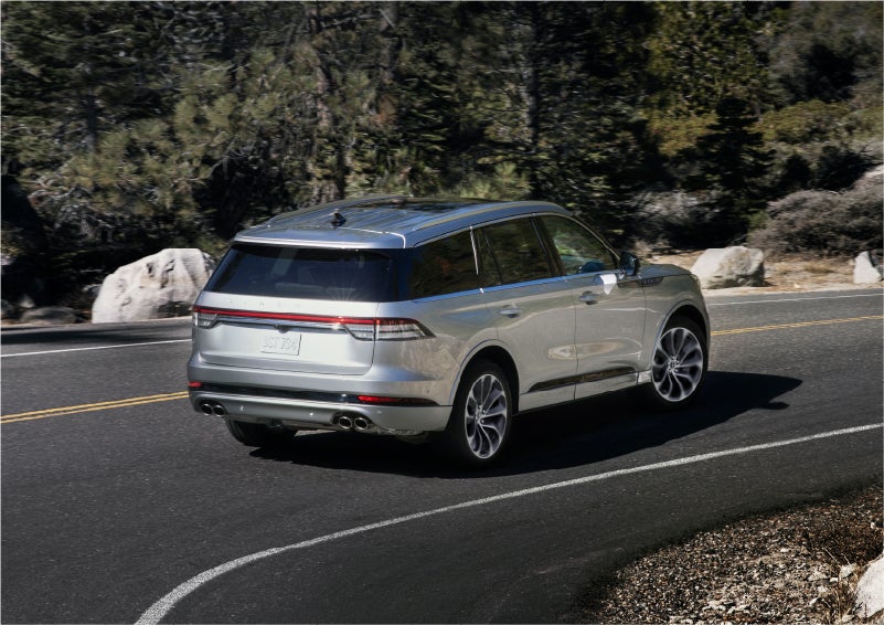 A 2023 Lincoln Aviator® Grand Touring model is shown being driven on a tight turn of a mountain road | Thomasville Lincoln in Thomasville GA