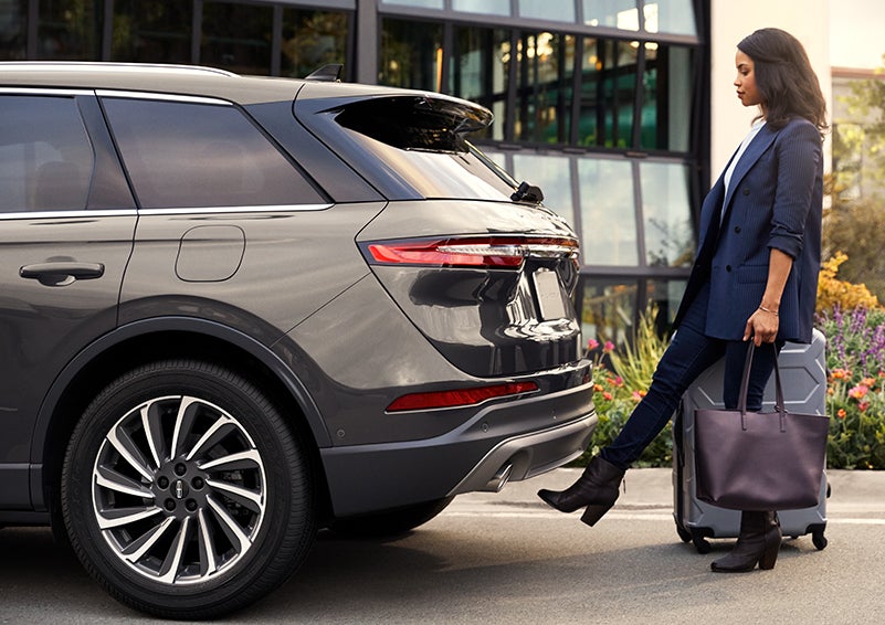 A woman with her hands full uses her foot to activate the available hands-free liftgate. | Thomasville Lincoln in Thomasville GA