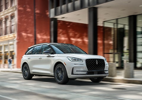 The 2024 Lincoln Corsair® SUV with the Jet Appearance Package and a Pristine White exterior is parked on a city street. | Thomasville Lincoln in Thomasville GA